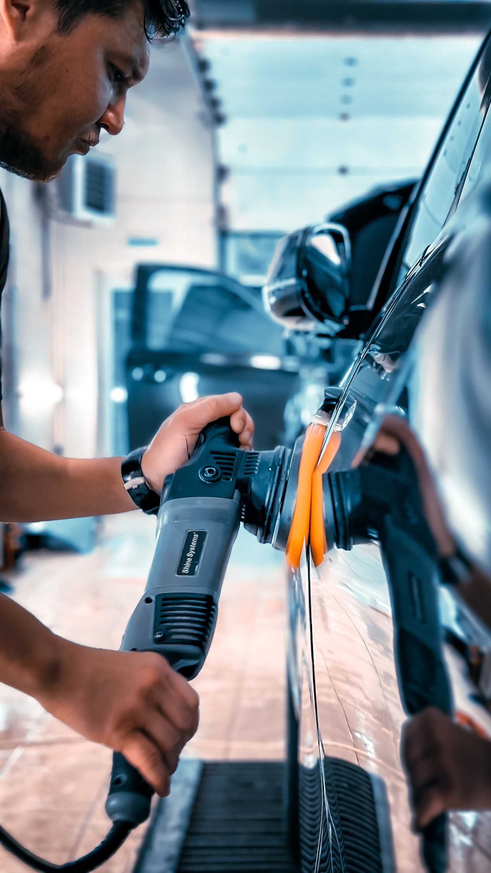 Detailer polishing a car panel by hand