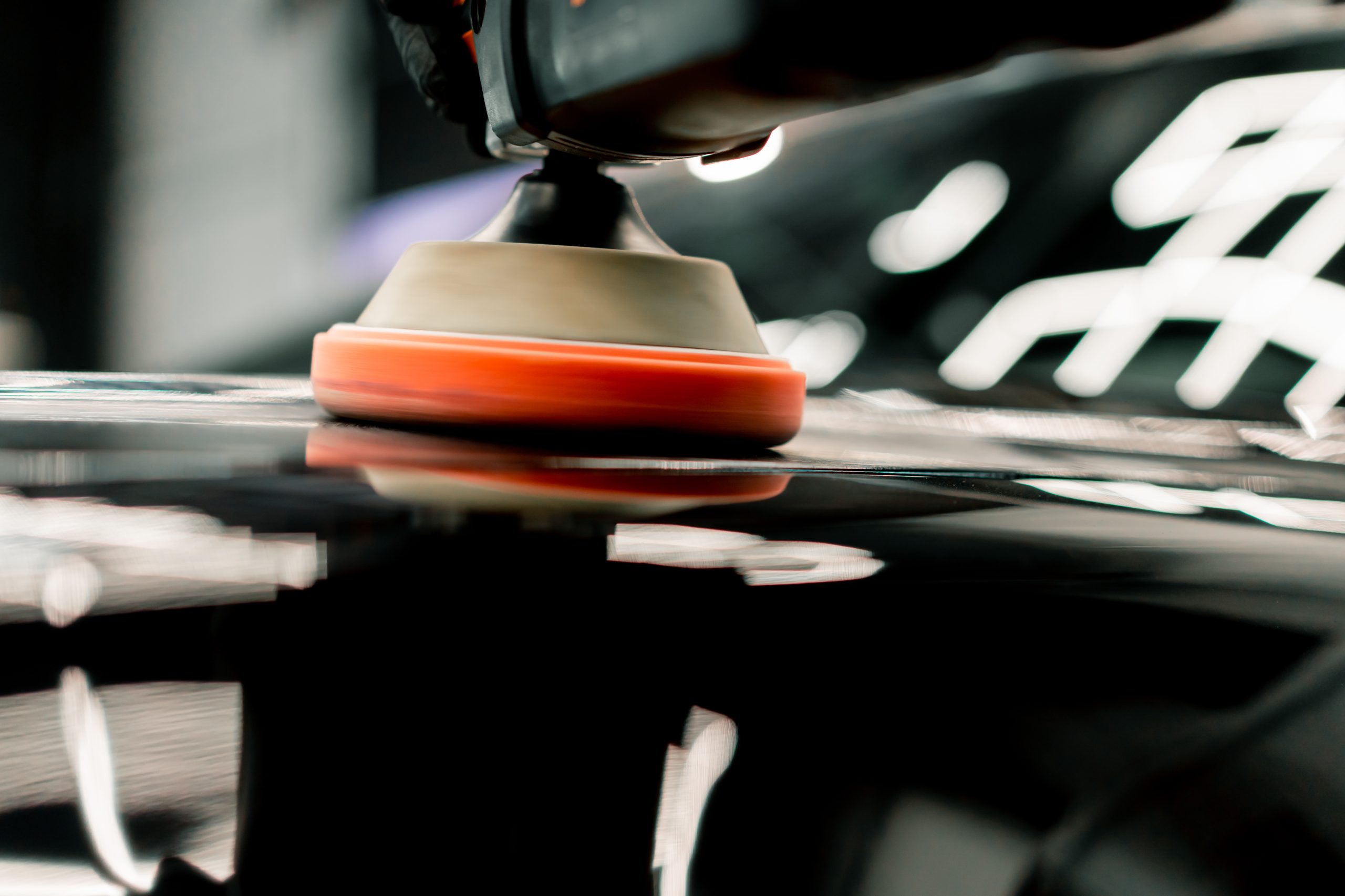 Detailer hand-polishing a car exterior